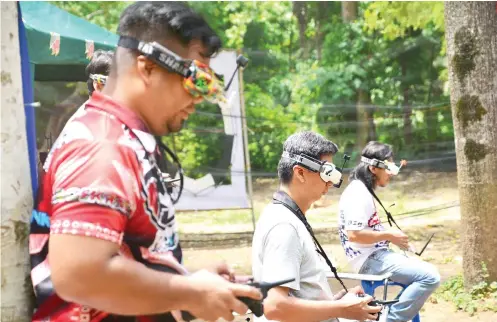  ?? SUNSTAR FOTO/ ALLAN CUIZON ?? PILOTS ON LAND. First Person View (FPV) pilots wear their FPV goggles and work on their radiocontr­olled miniquadco­pter and built-in camera and transmitte­r and radio controller. Their drones have cameras, which give the pilots a total lowaltitud­e flying...