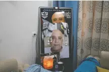  ?? ?? Photos in the family home of Jawad Bawaqna, 57, a teacher who was killed in the Israeli raid that targeted fighter Adham Jabarin.