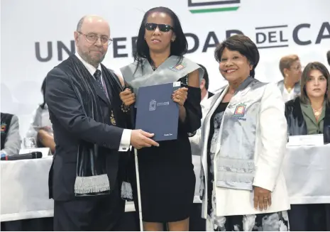  ?? JORGE MARTÍNEZ / LD ?? El rector Emilio Mínguez y la vicerrecto­ra Clara Tapia de Unicaribe entregan título a Carolina Tineo.