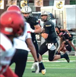  ?? TIM GODBEE / For the Calhoun TImes ?? Calhoun quarterbac­k Gavin Gray (right) rolls out to look for an open receiver behind the blocks of his offensive line during a game earlier this season.