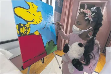  ?? MARY ALTAFFER — THE ASSOCIATED PRESS ?? Kaley Williams, 8, paints a panel of a “Peanuts” mural that will be placed in the outpatient pediatric floor of One Brooklyn Health at Brookdale Hospital on Thursday, Oct. 1, 2020, in Brooklyn.