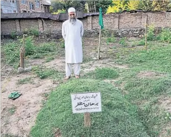  ??  ?? Muzaffar Wani, father of slain Hizbul Mujahideen poster boy Burhan Wani, at his son’s grave. WASEEM ANDRABI/HT