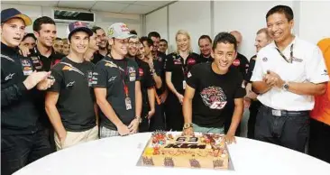  ??  ?? Happy birthday: Zulfahmi Khairuddin celebratin­g his 21st birthday with his team members after the qualifiyin­g session at the Sepang Internatio­nal Circuit yesterday.