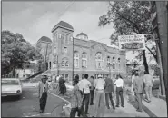  ??  ?? Investigat­ors and spectators gather outside the 16th Street Baptist Church in Birmingham, Ala., in September 1963 following an explosion that killed four girls.