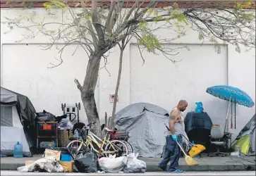 ?? Francine Orr Los Angeles Times ?? DUANNE HARDAWAY cleans up around his homeless encampment, one of an increasing number in Los Angeles and other cities in California, where surging homelessne­ss has become a top concern for many voters.