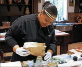  ?? PHOTO BY EMILY RYAN ?? Executive chef Chiwishi Joy Abney prepares for a class at the Wayne Art Center.