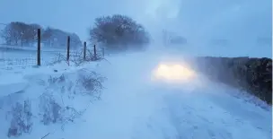  ??  ?? This picture of a car stuck in a snowdrift on Bull Hill, Rainow, was shared by Macclesfie­ld Police