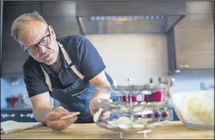  ?? BRYAN MELTZ / THE NEW YORK TIMES ?? Alton Brown prepares barbecued potato chips at his suburban compound in Marietta. His new cookbook, “EveryDayCo­ok: This Time It’s Personal” offers fans a peek into how the Food Network star cooks and eats at home.