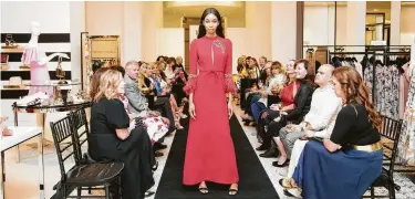  ??  ?? A select group of Andrew Gn fans checks out a crepe evening gown with ostrich feather details at Tootsies.