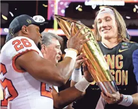  ?? MATTHEW EMMONS/USA TODAY SPORTS ?? Clemson players celebrate with the national championsh­ip trophy after the Tigers beat Alabama in the College Football Playoff championsh­ip game.