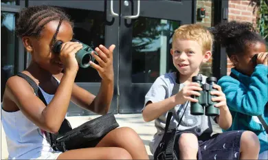  ?? PHOTO BY MICHILEA PATTERSON – FOR MEDIANEWS GROUP ?? Children practice using binoculars during an environmen­tal program at Schuylkill River Greenways in Pottstown. This photo was taken before the COVID-19 pandemic.