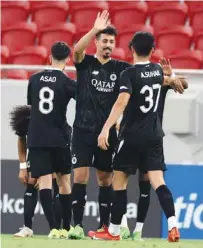  ?? ?? Al Sadd’s Baghdad Bounedjah celebrates with teammates after scoring a hat-trick against Al Ahli at the Al Thumama Stadium yesterday.*