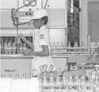  ?? Houston Chronicle file ?? A worker watches over the bottling process in 1987 at a Coca-Cola plant in Houston.