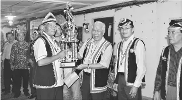  ??  ?? Manyin (third right) hands over the winner’s trophy to Kampung Darul Islam Belimbing headman Hussein Banyak, as (from right) Pemanca Kane Manung, Raymond and others look on.