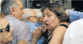  ?? Picture: REUTERS ?? UNDER PRESSURE: A pensioner undergoing oxygen therapy struggles in the crush of people trying to enter a bank to receive part of her pension in the Greek city of Thessaloni­ka