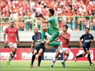  ?? WAHYUDIN/JAWA POS ?? LENGKET: Kiper PSM Rivky Mokodompit mengamanka­n bola dari serangan pemain Persija kemarin (15/8).