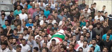  ??  ?? Palestinia­ns carry the body of 48-year-old mother of eight, Aisha Rabi, who died of her wounds after the car she was travelling in with her husband was hit by stones, during her funeral in the West Bank village of Bidya, near Salfit, yesterday.