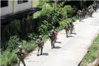  ?? (Reuters) ?? PHILIPPINE MARINES advance against ISIS-affiliated rebels in Marawi City yesterday.