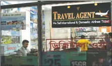  ??  ?? Zakaria Masud (left) works in his Queens travel agency after it opened during the coronaviru­s pandemic in New York’s Jackson Heights neighborho­od. “I think we’re losing 50% of the revenue. But I think we can survive,” said Masud.
(AP/Mark Lennihan)