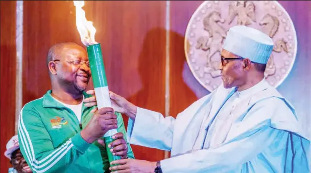 ??  ?? President Muhammadu Buhari (R) handing over the ‘Unity Torch’ for the postponed 2020 National Sports Festival to Minister of Sports, Sunday Dare
