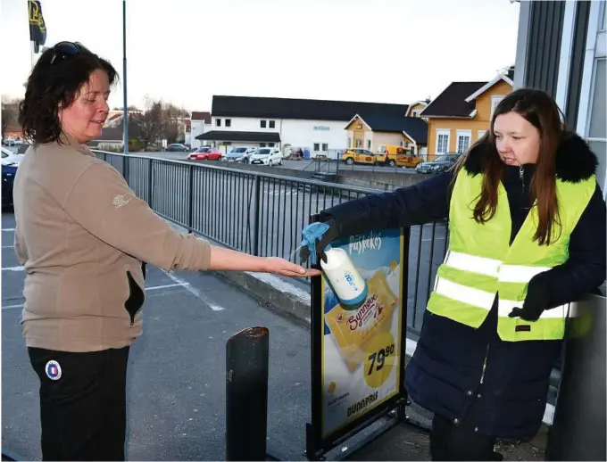  ?? FOTO: CAMILLA HOVSTØ ?? Bunnpris har innført køordning utenfor den søndagsåpn­e butikken. Her får Jorunn Frivold håndsprit av butikkvakt Helene Jensen, før hun går inn i butikken.