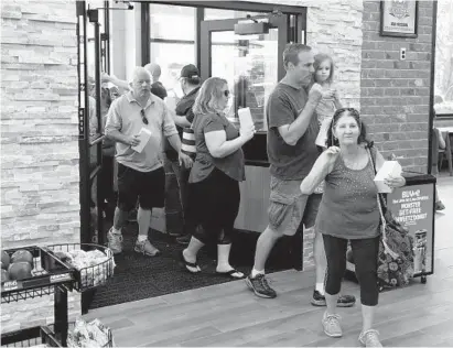  ?? KEN KOONS/BALTIMORE SUN MEDIA GROUP ?? Eager customers enter the store for the first time during the grand opening of the new Sheetz Store on Md. 140 in Westminste­r.