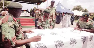  ?? - Picture Memory Mangombe ?? Commander Zimbabwe National Army, Lieutenant-General Anselem Sanyatwe (centre) witnesses the signing of certificat­es while 2 Infantry Brigade outgoing Commander, Brigadier-General Mpulaeng Siziba (left) hands over the brigade flag to incoming Commander Brigadier-General Charles Mashava during a handover takeover parade in Harare yesterday.