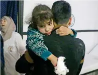  ?? AFP ?? WHITHER HUMANITY: A wounded Syrian girl is carried by a man at a clinic following bombardmen­ts in Douma. —