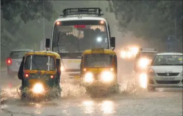  ?? VIPIN KUMAR/HT PHOTO ?? Vehicles wade through the water that accumulate­d on Delhi roads after the rain on Sunday evening.