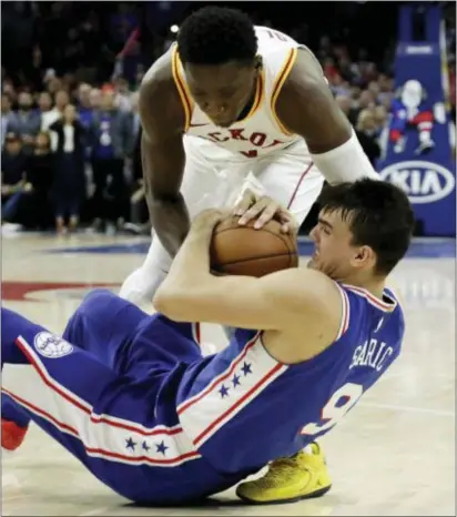  ?? MATT SLOCUM — THE ASSOCIATED PRESS ?? Indiana’s Victor Oladipo, top, and the 76ers’ Dario Saric battle for the ball on Tuesday. Indiana won, 101-98.