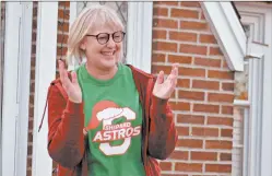  ??  ?? Retiring Shepard High School teacher Kate Richardson claps along to a song after her peers showed up to sing Christmas carols at her house Tuesday in Palos Heights.