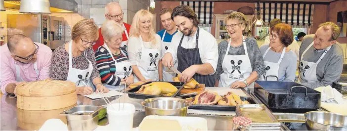  ?? FOTOS: SUSI DONNER ?? Kochen lernen von einem der Besten der Region: Andreas Früh, Elisabeth Hakvoort, Gudrun Hoppe, Christoph Breunig, Susanne Stangl, Matthias Schlierenz­auer, Jutta Cosalter, Gerdi Vogler, Rüdiger Lambert schmiegen sich beim interessie­rten Zuschauen beinahe an Sternekoch Toni Neumann an.