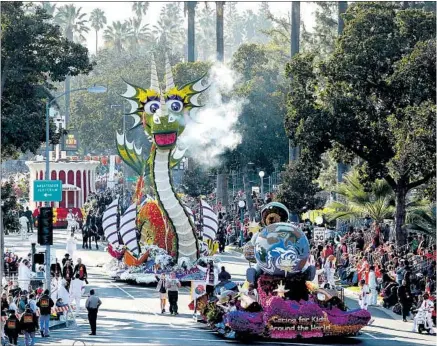  ?? Patrick T. Fal ?? A DRAGON on UPS Store Inc.’s “Books Bring Dreams to Life” f loat follows the Shriners Hospital’s “Caring for Kids Around the Wo