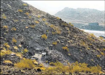  ??  ?? The entrance to Richard Roman’s home in an abandoned mine shaft blends into the hillside above the River Mountains Loop Trail east of Railroad Pass Casino.