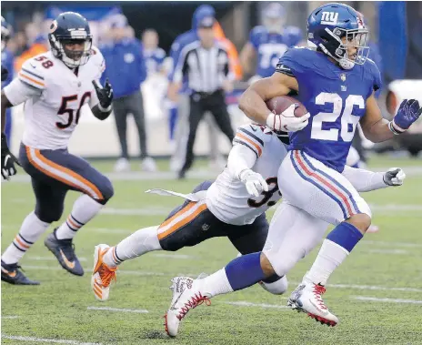  ?? SETH WENIG/THE ASSOCIATED PRESS ?? New York Giants running back Saquon Barkley had a big game against the Chicago Bears and free safety Eddie Jackson Sunday in East Rutherford, N.J., racking up 125 rushing yards in the Giants’ 30-27 overtime win against the NFC North-leading Bears.