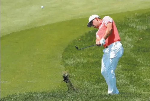  ?? AP PHOTO ?? Gary Woodland hits out of the deep rough to the eighth green during the second round of the PGA Championsh­ip on Friday at Bellerive Country Club inSt. Louis. Woodland has a one-shot lead over Kevin Kisner.