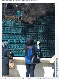 ??  ?? A woman touches the railing around the Abu Ayyub al-Ansari shrine to pray.