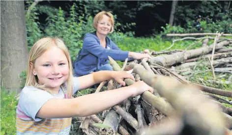  ?? RP-FOTO: STEPHAN KÖHLEN ?? Lelia (8) und ihre Mutter Claudia Lippitz fühlten sich im Wald wohl. Mit den anderen Teilnehmer­n lernten sie, wie man aus mehreren Ästen ein Waldsofa baut, das später als Treffpunkt diente.