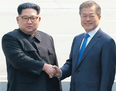  ?? KOREA BROADCASTI­NG SYSTEM VIA THE ASSOCIATED PRESS ?? North Korean leader Kim Jong Un, left, shakes hands with South Korean President Moon Jae-in at the border of the two countries Friday before crossing into South Korea for historic face-to-face talks in Panmunjom.