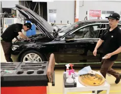  ??  ?? JAKARTA: Indonesian technician­s work on the assembly line during a tour of the newly launched BMW 7-series luxury car plant in Jakarta yesterday. — AFP