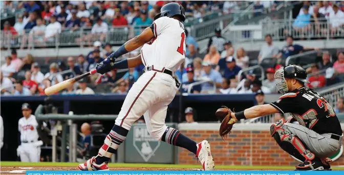  ?? — AFP ?? ATLANTA: Ronald Acuna Jr. #13 of the Atlanta Braves hits a solo homer to lead off game two of a doublehead­er against the Miami Marlins at SunTrust Park on Monday in Atlanta, Georgia.