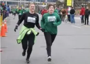  ??  ?? Kim Umbach, right, and her guide, enroute during the Achilles St. Patrick’s Day 5 km run.