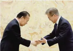  ??  ?? SEOUL: South Korean President Moon Jae-in shakes hands with Toshihiro Nikai, Secretary General of the Japanese Liberal Democratic Party, during their meeting at the Presidenti­al Blue House yesterday. —AFP