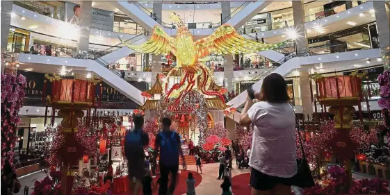  ??  ?? Higher allocation: Visitors walk past a giant rooster installati­on at a mall in Kuala Lumpur. Of the average Lunar New Year budget of RM4,201, a 9% increase from RM3,846 in 2016, respondent­s in a survey say they will allocate RM1,008 for food, a 14%...