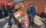  ?? KEVIN MARTIN — THE MORNING JOURNAL ?? Volunteers from Dura-Line help distribute food donations from Second Harvest Food Bank of North Central Ohio at Beyond the Walls Church in Elyria on Jan. 11.