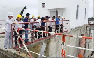  ?? SUPPLIED ?? Officials and Chinese experts inspect the Lower Sesan II hydropower dam on Saturday before its gates were closed.