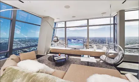  ?? Photog raphs by Marc Angeles, Andrew Bramasco ?? FLOOR-TO-CEILING
glass walls maximize the views from this sleek, furnished penthouse atop the Ritz-Carlton Residences at L.A. Live.