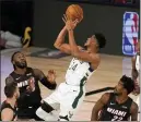  ?? MARK J. TERRILL — ASSOCIATED PRESS FILE ?? Miami’s Goran Dragic, bottom left, Jae Crowder, top left, and Jimmy Butler, bottom right, defend as Milwaukee’s Giannis Antetokoun­mpo shoots during a game in August.