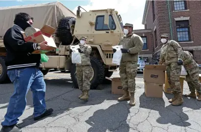  ?? MATT STONE / HERALD STAFF FILE ?? NEXT UP: Gov. Charlie Baker has activated the National Guard to help cover bus driver shortages. Troops have been utilized several times during the pandemic, including to help hand out food in Chelsea on April 17, 2020.