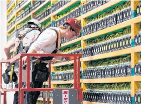  ?? AFP ?? Two workers inspect servers at the Bitcoin mining company Bifarms in Saint Hyacinthe, Quebec.
